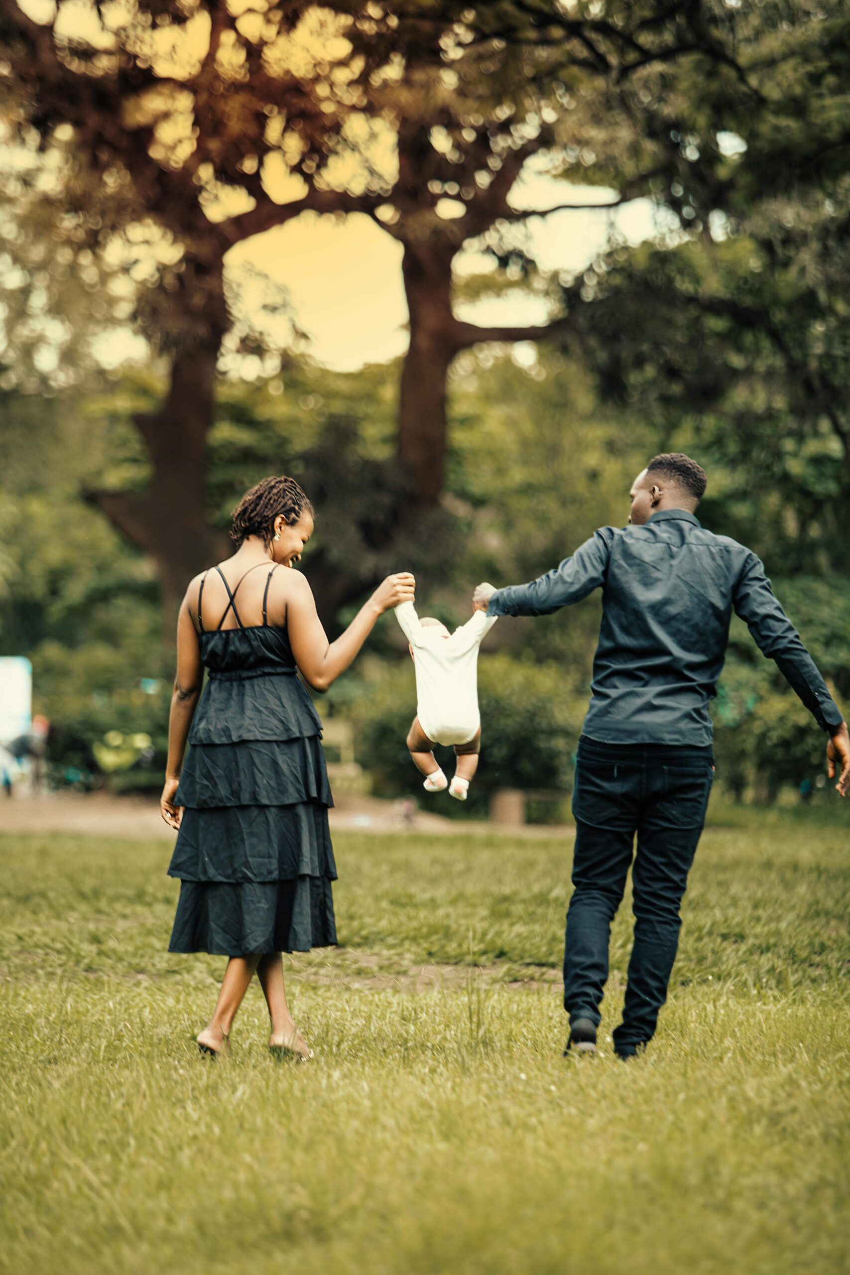 A joyful family of three enjoying a walk in a green park, capturing a special moment.